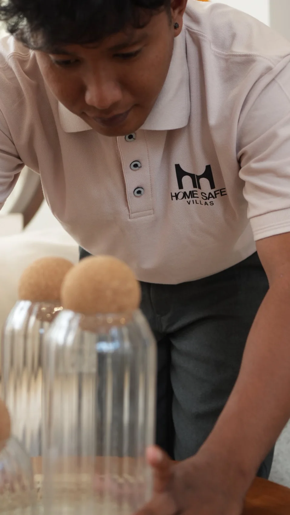 Homesafe Villas team member preparing a table in a branded uniform